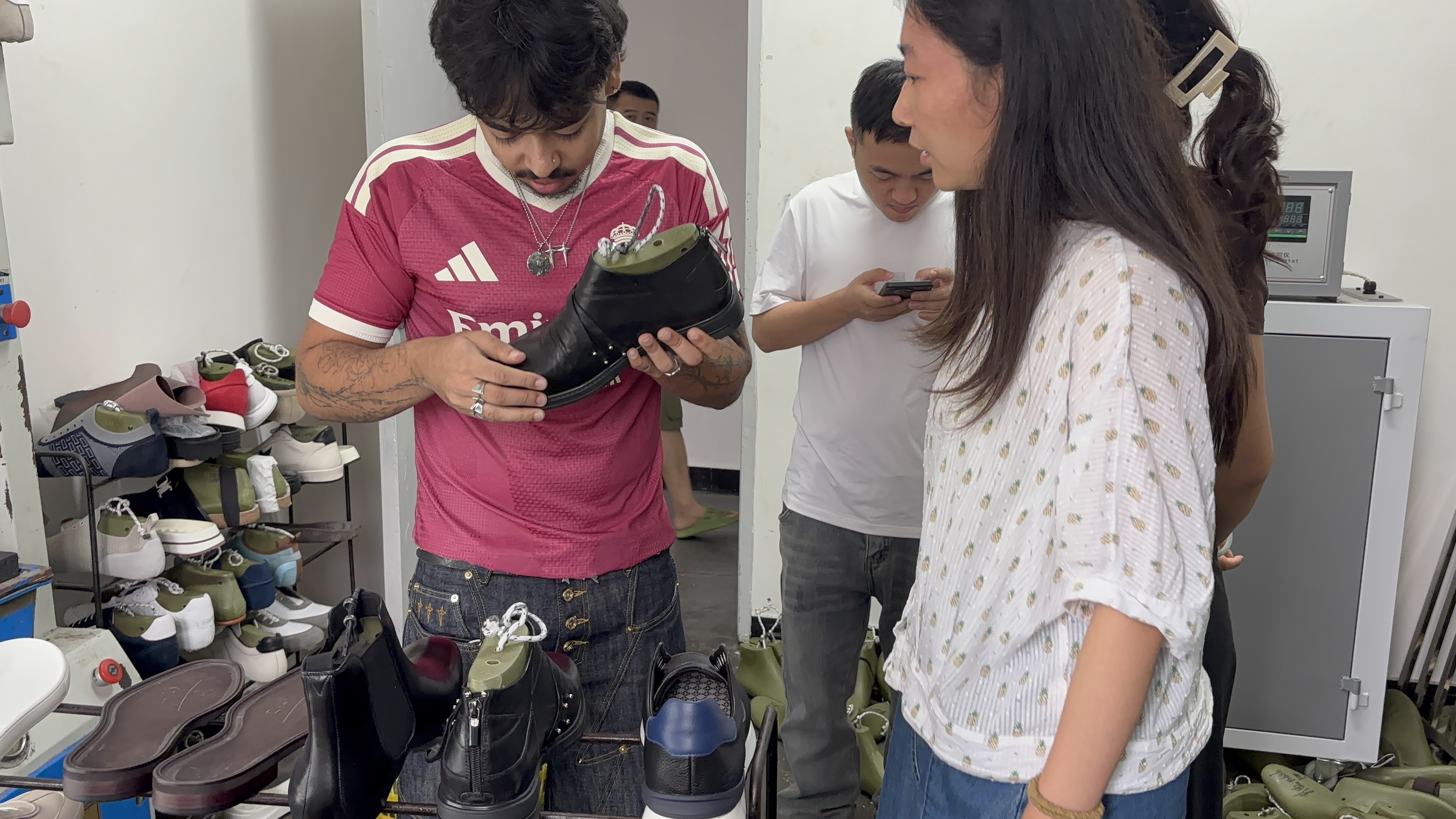 International buyer inspecting finished black leather shoes at LANCI custom shoes factory