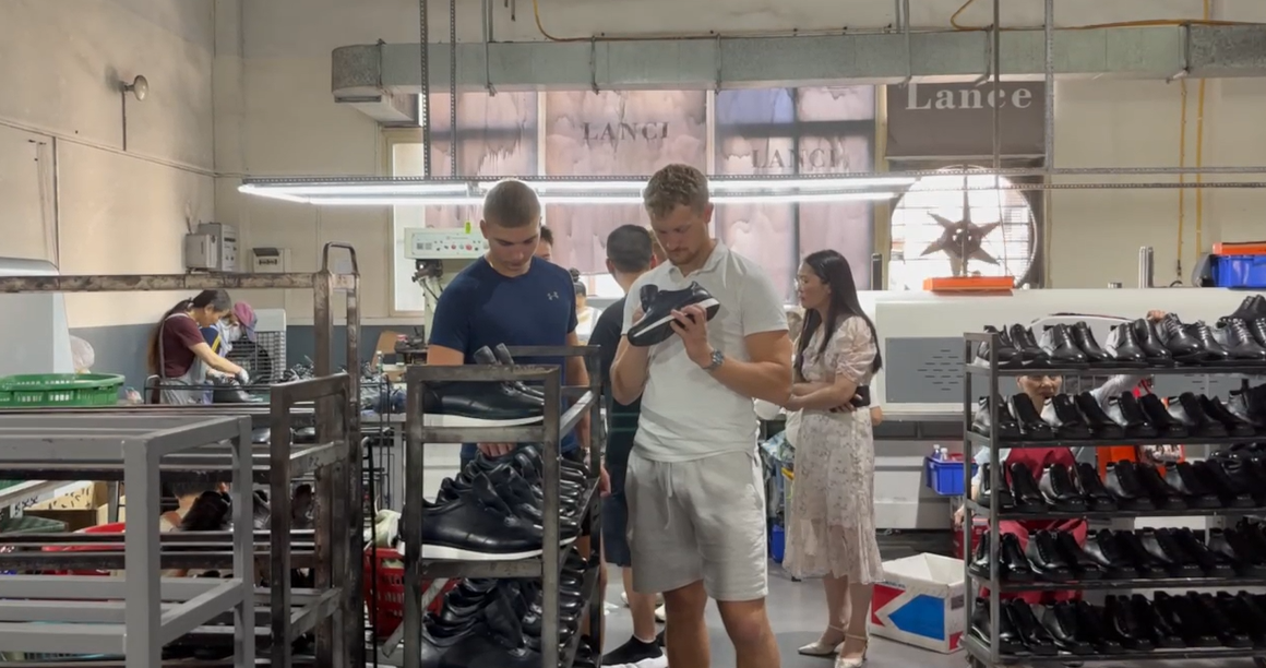 Overseas buyers inspecting finished leather shoes on production racks at LANCI shoes factory