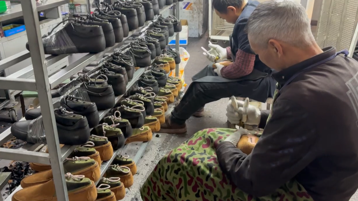 Rows of shoe lasts and semi-finished custom shoes in LANCI factory workshop for quality inspection